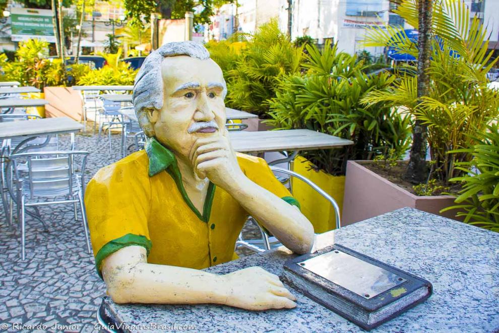 Imagem de uma escultura humana sentado na mesa de um restaurante.